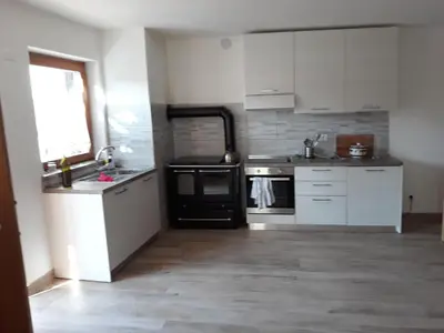 a living room with a television and a kitchen at Ca DaSa in San Lugano