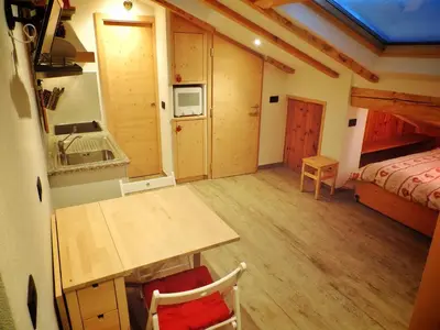 a small room with a kitchen and a bedroom at incantevole mansarda in val di Fassa in Alba di Canazei