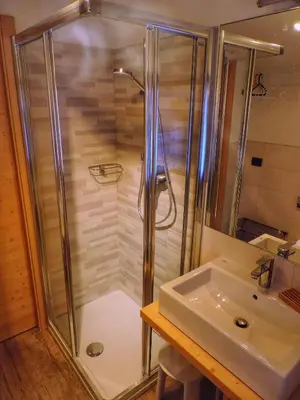 a shower with a glass door next to a sink at incantevole mansarda in val di Fassa in Alba di Canazei
