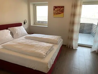 a bedroom with two beds and a window at Apartments ANNY in Postal