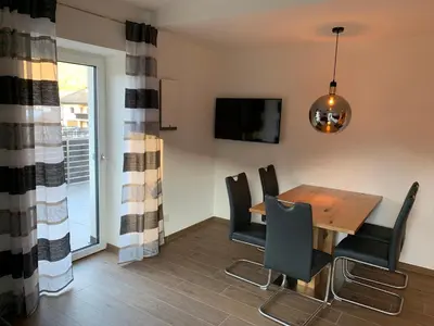 a dining room with a wooden table and chairs at Apartments ANNY in Postal