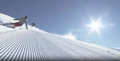 two people are skiing down a snow covered slope at Relax Suite in Merano