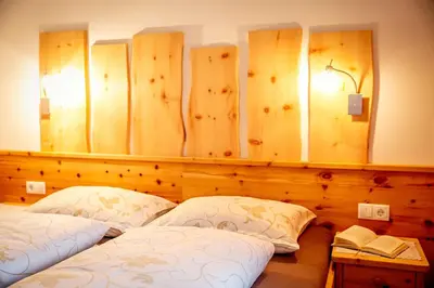 a bedroom with two beds and a wall with mirrors at Oberhauser Hof - Apartments in Feldthurns