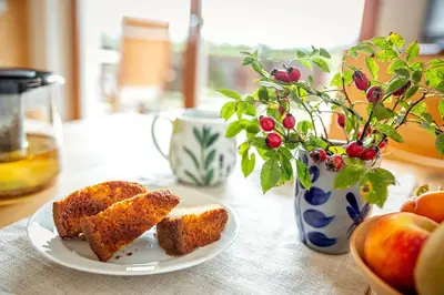 a table with a plate of bread and a vase with fruit at Oberhauser Hof - Apartments in Feldthurns