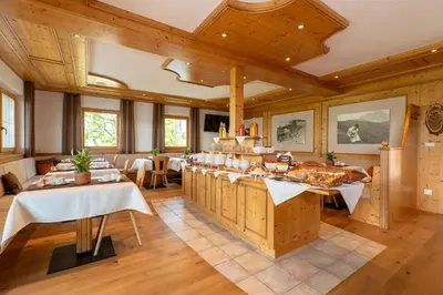a large dining room with wooden walls and wooden ceilings at Pension-Appartement Mitterhofer in Schenna