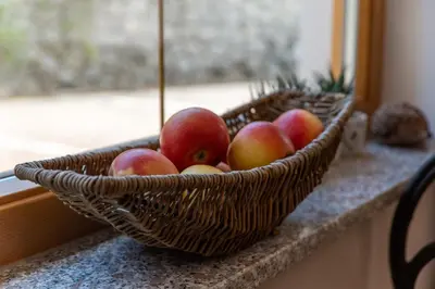 a basket of apples sitting on a counter next to a window at Pension-Appartement Mitterhofer in Schenna
