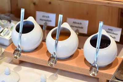 three bowls of coffee on a shelf with spoons at Pension-Appartement Mitterhofer in Schenna