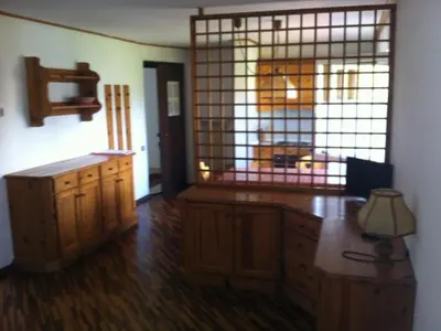 a kitchen with wooden cabinets and a large window at Casa Cavalese sul Cermis in Cavalese
