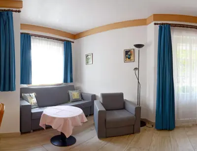 a living room with a couch and a chair and a table at Casa Roder by Garni Snaltnerhof in Ortisei