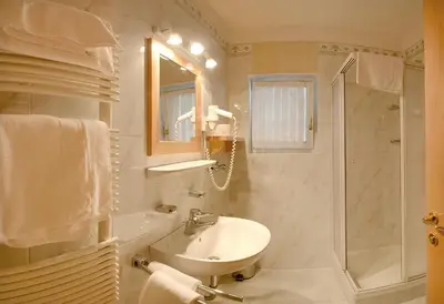 a white bathroom with a sink and a shower at Casa Roder by Garni Snaltnerhof in Ortisei