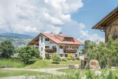 a large white house on top of a hill at Ebenhof in Collepietra
