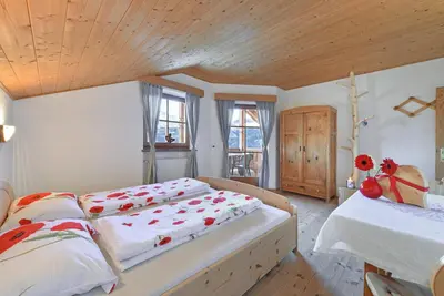 a bedroom with two beds and a wooden ceiling at Ebenhof in Collepietra