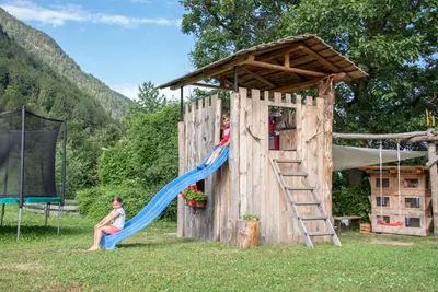 a girl is sitting on a slide on a playground at Ebenhof in Collepietra