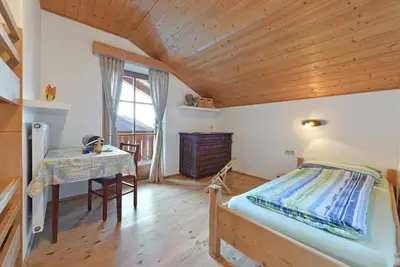 a bedroom with a bed and a desk and a table at Ebenhof in Collepietra