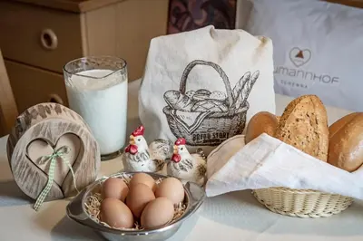 a table with eggs and bread and a glass of milk at Baumannhof in Schenna