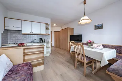 a kitchen and a living room with a table and a kitchen and a dining room at Baumannhof in Schenna