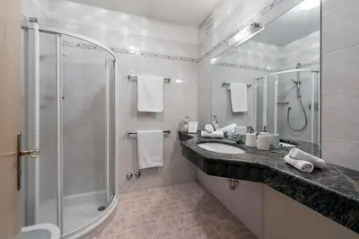 a bathroom with a glass shower and a sink at Baumannhof in Schenna