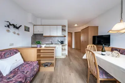 a kitchen and living room with a table and a couch at Baumannhof in Schenna