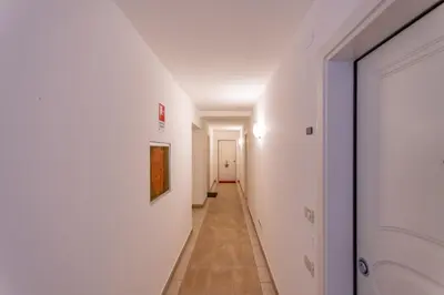 a hallway with white walls and a tile floor at Casa Rosi in Pozza di Fassa