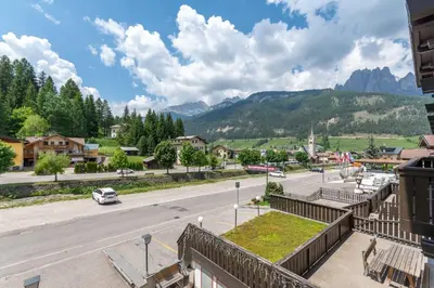 a view of a street in a town with mountains at Casa Rosi in Pozza di Fassa