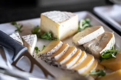 a plate of food with cheese and a knife at Gfell in Vols am Schlern