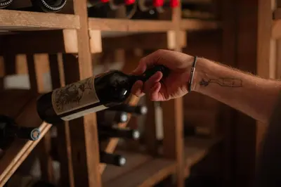 a person is holding a bottle of wine at Gfell in Vols am Schlern