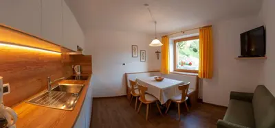 a kitchen and dining room with a table and a sink at Appartment Kirch Neuhaus in Laion