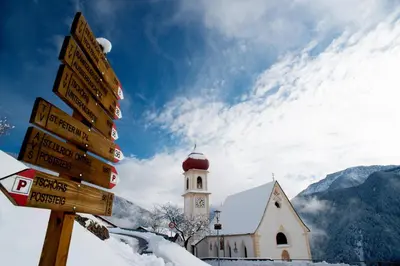a street sign in front of a church in the snow at Appartment Kirch Neuhaus in Laion