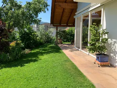 a house with a yard with a patio and grass at Haus Greti in Magrè allʼ Adige