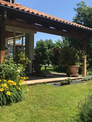 a pergola with a chair in a yard at Haus Greti in Magrè allʼ Adige