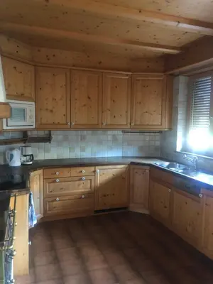 a kitchen with wooden cabinets and a sink and a microwave at Haus Greti in Magrè allʼ Adige