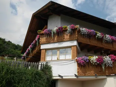 a house with flower boxes on the balcony at B&B Brunnerhof in Feldthurns