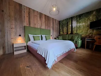 a bedroom with a large bed and wooden walls at B&B Brunnerhof in Feldthurns