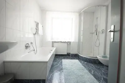 a white bathroom with a tub and a sink at Village Charme in Molini di Tures