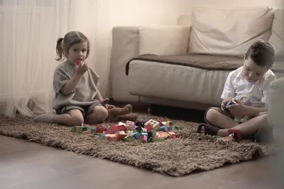 a boy and a girl sitting on the floor playing with toys at Village Charme in Molini di Tures