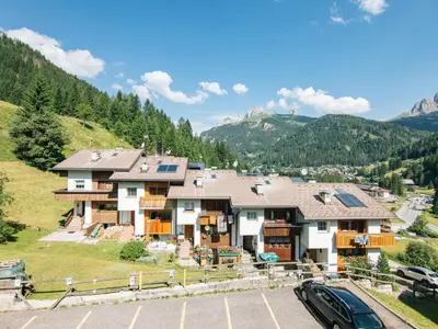 a house in the mountains with a car parked in front at Apartment Enrosadira-7 by Interhome in Alba di Canazei