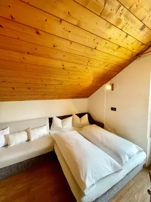 a bed in a room with a wooden ceiling at Apartments Spirit of Mountains in Rasun di Sopra