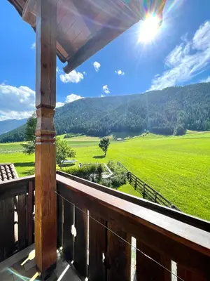 a balcony with a view of a green field at Apartments Spirit of Mountains in Rasun di Sopra