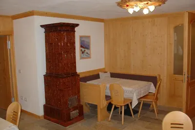 a dining room with a table and a brick pillar at Agritur al Canyon in Cloz