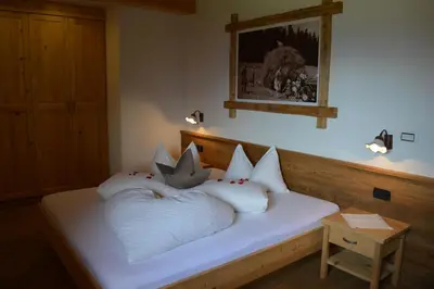 a bed with white pillows on it in a room at Tiefentalhof - Urlaub am Bauernhof in Tesido