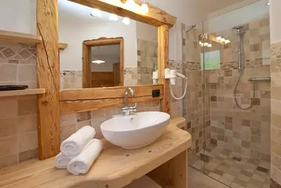 a bathroom with a sink and a shower at Tiefentalhof - Urlaub am Bauernhof in Tesido