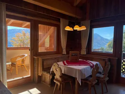 a dining room with a table and two windows at Tiefentalhof - Urlaub am Bauernhof in Tesido