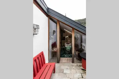 a red bench sitting on the side of a house at Zweizimmer-Wohnung mit Schlossblick in Chiusa