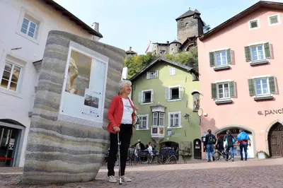a woman standing next to a monument in a street at Zweizimmer-Wohnung mit Schlossblick in Chiusa