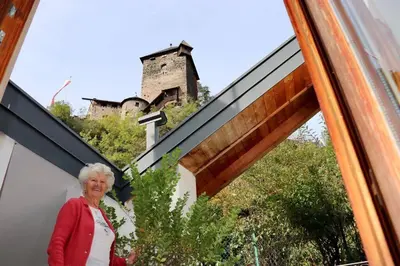 an older woman standing in front of a glass window at Zweizimmer-Wohnung mit Schlossblick in Chiusa
