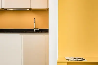 a kitchen with white cabinets and a sink at Apartments Seewinkel in Caldaro