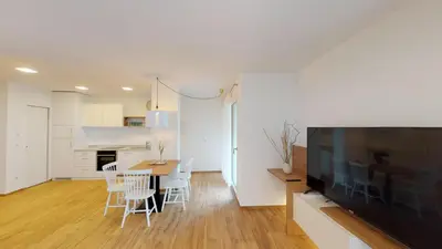 a living room with a dining room table and a television at Lorent House in Merano