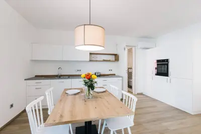 a kitchen with a wooden table with a vase of flowers at Lorent House in Merano