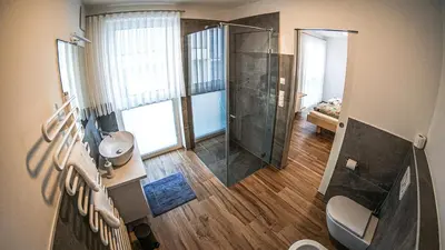 a bathroom with a shower and a toilet and a sink at Lorent House in Merano