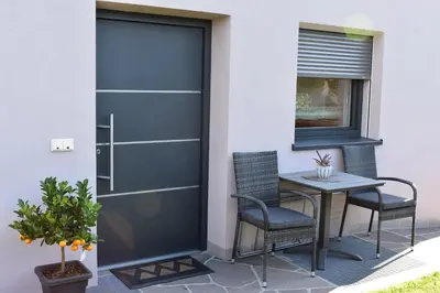 a patio with a table and chairs next to a door at Ferienwohnung Pippohof in Appiano sulla Strada del Vino